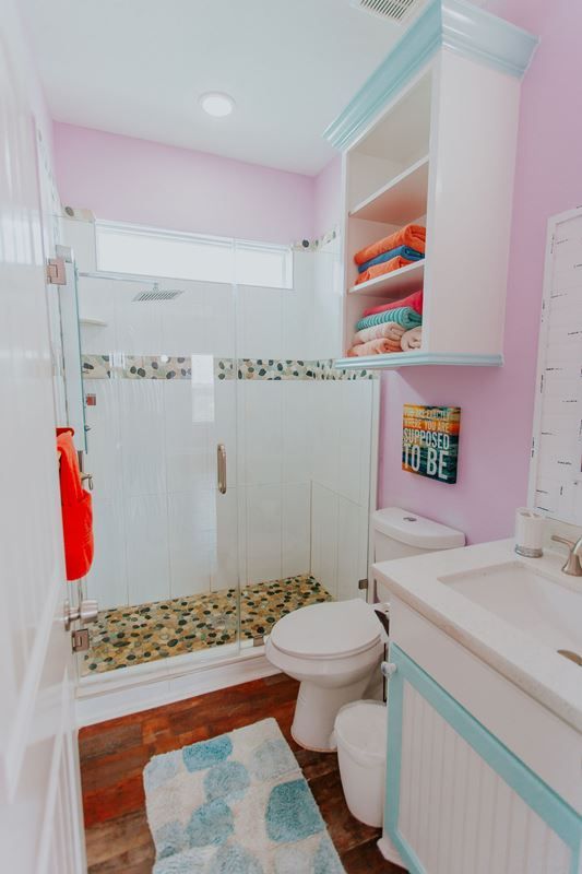 A bathroom with a toilet , sink and shower.