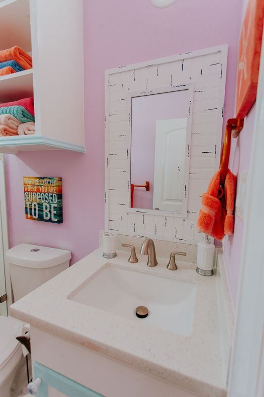 A bathroom with a sink a toilet and a mirror