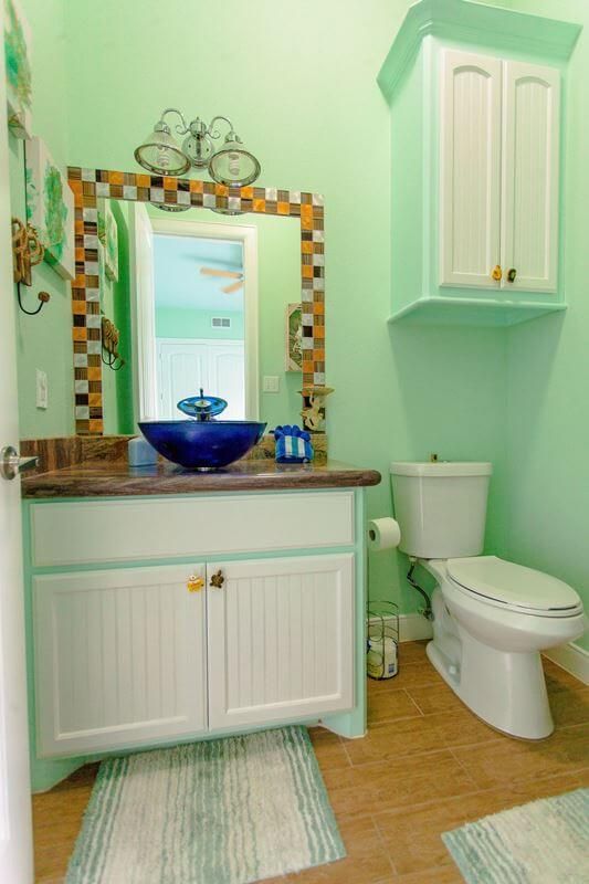 A bathroom with a toilet , sink and mirror