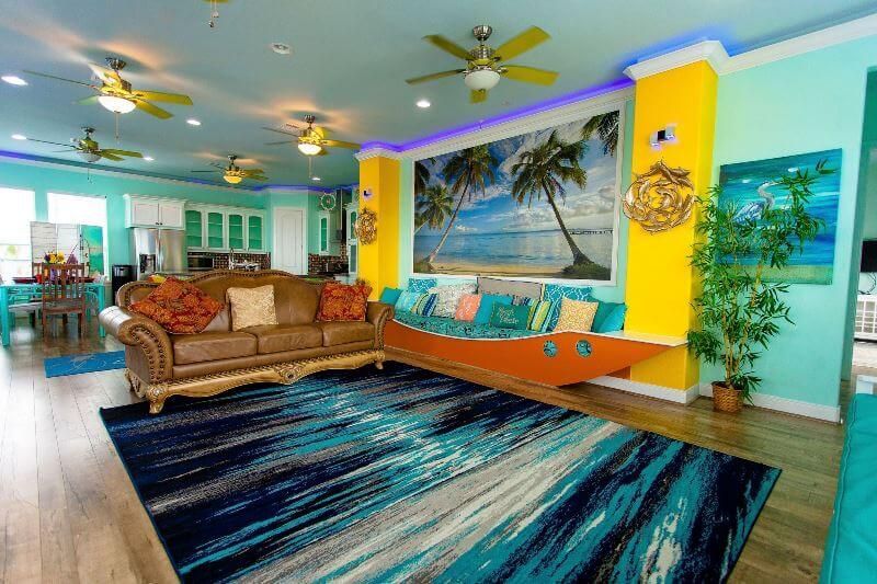 A living room with a couch , rug , and ceiling fan.