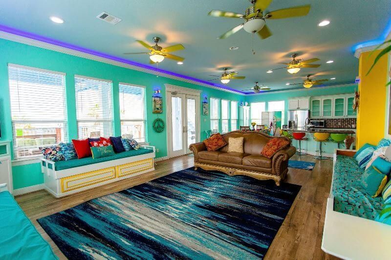 A living room with a couch , rug , and ceiling fan.