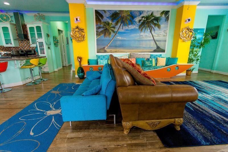 A living room with a couch , chair , rug and a painting on the wall.