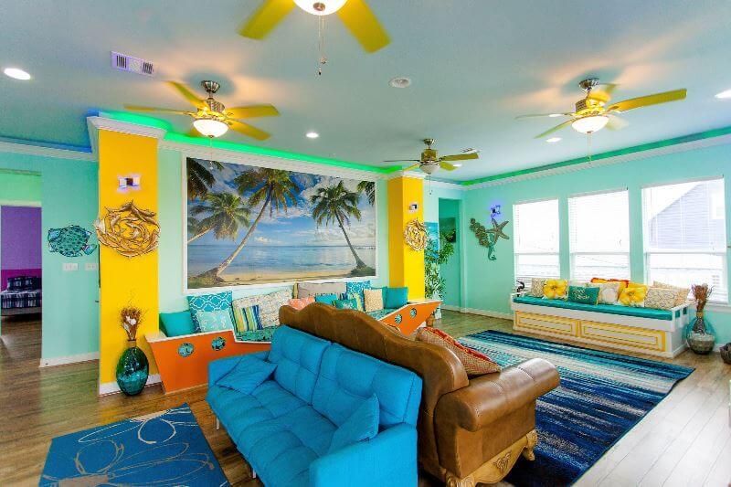 A living room with a blue couch and a ceiling fan.