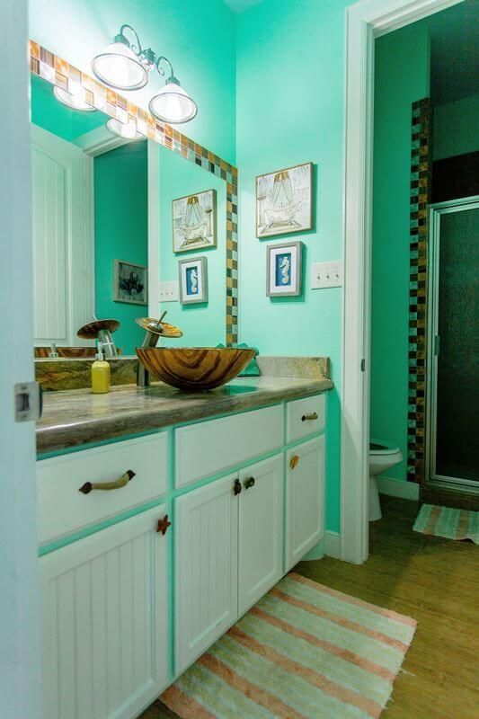A bathroom with a sink , mirror , toilet and shower.