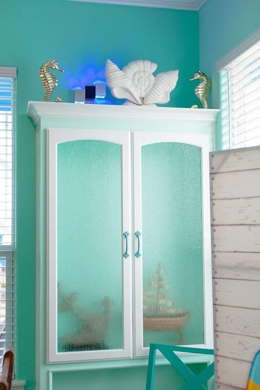 A white cabinet with a seahorse on top of it