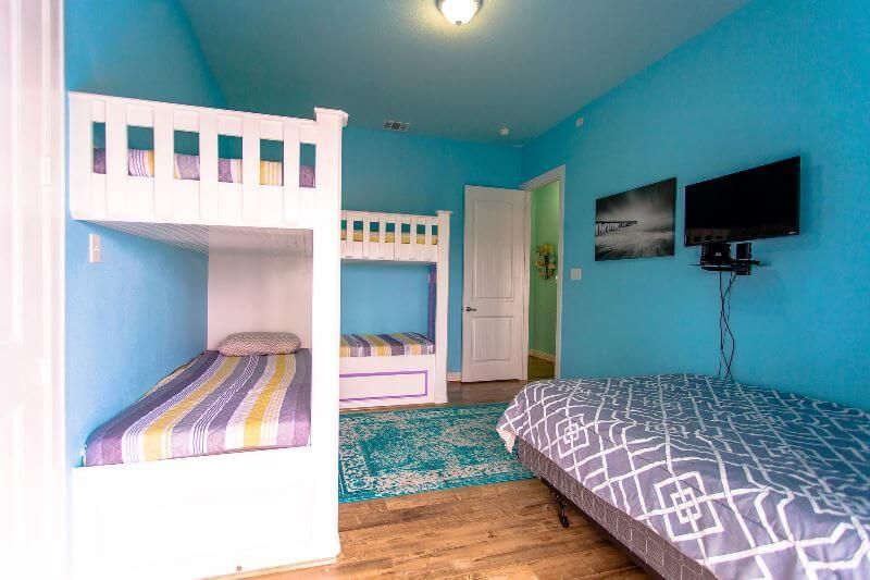 A bedroom with bunk beds and two beds.