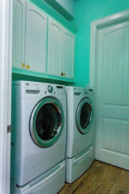 A laundry room with two washers and two dryers