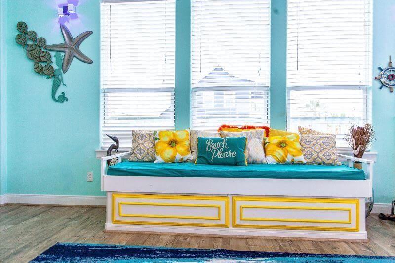A living room with a couch in front of a window.