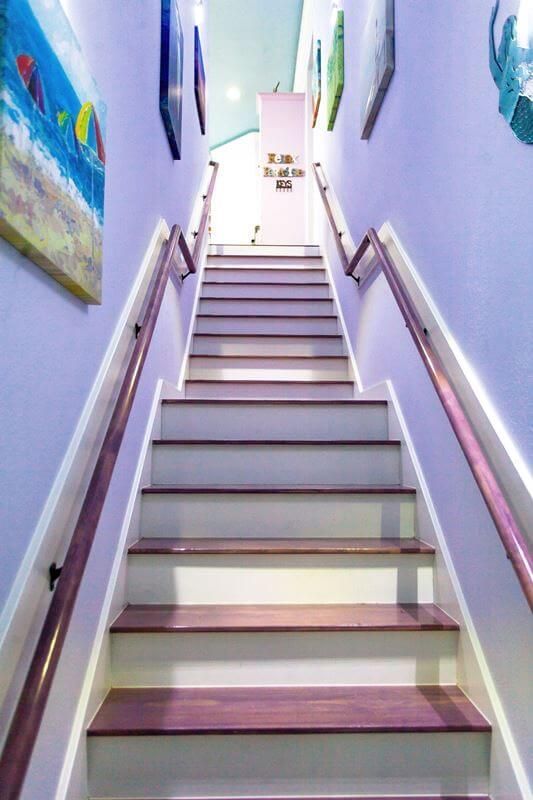 A set of stairs leading up to a purple wall