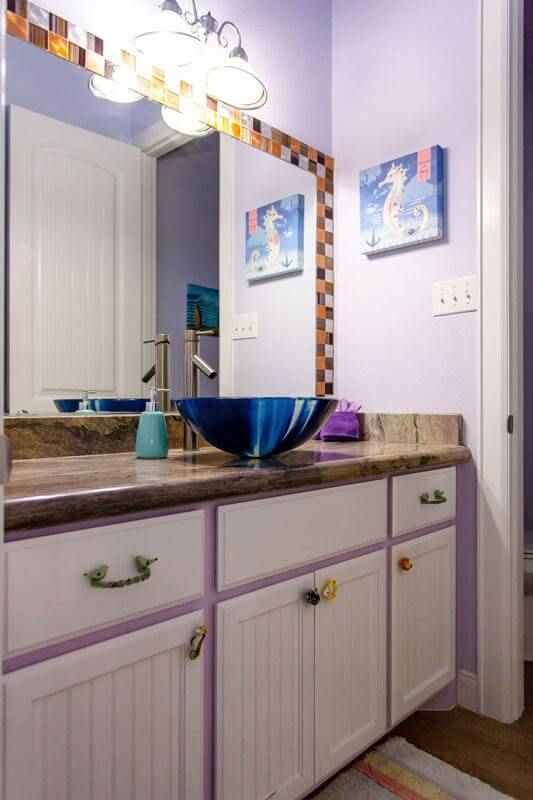 A bathroom with purple walls and a blue sink