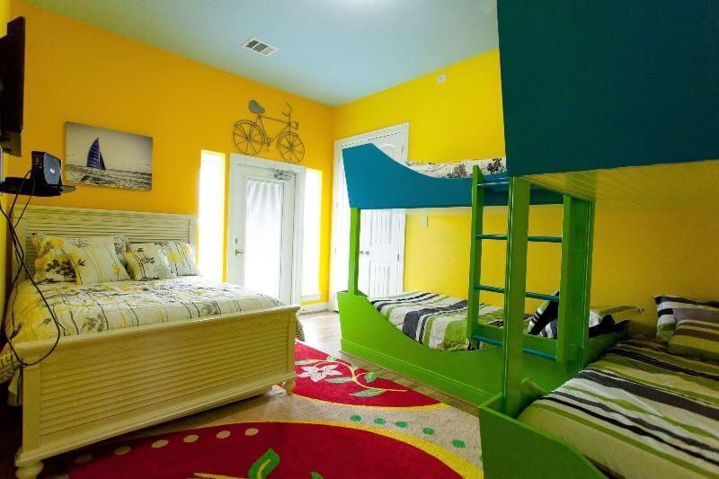 A bedroom with bunk beds , a bed , and a television.