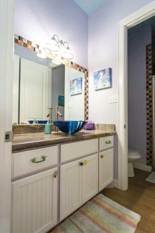A bathroom with a sink , mirror and toilet.