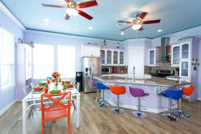 A kitchen with a table and chairs and a ceiling fan