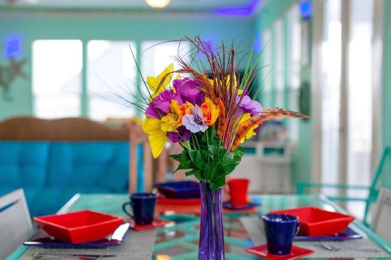 A vase of flowers is sitting on a dining table.