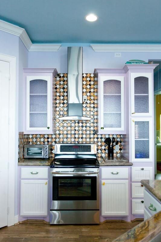 A kitchen with stainless steel appliances and purple cabinets