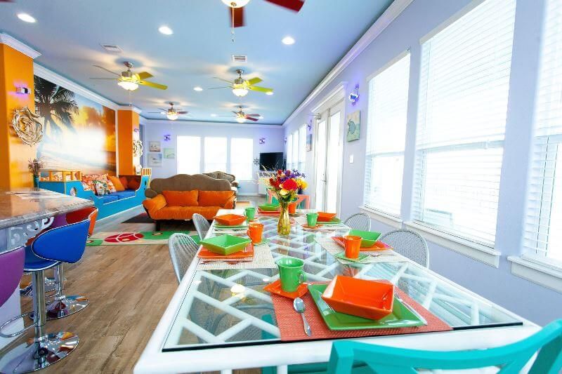 A living room with a dining table and chairs and a ceiling fan.