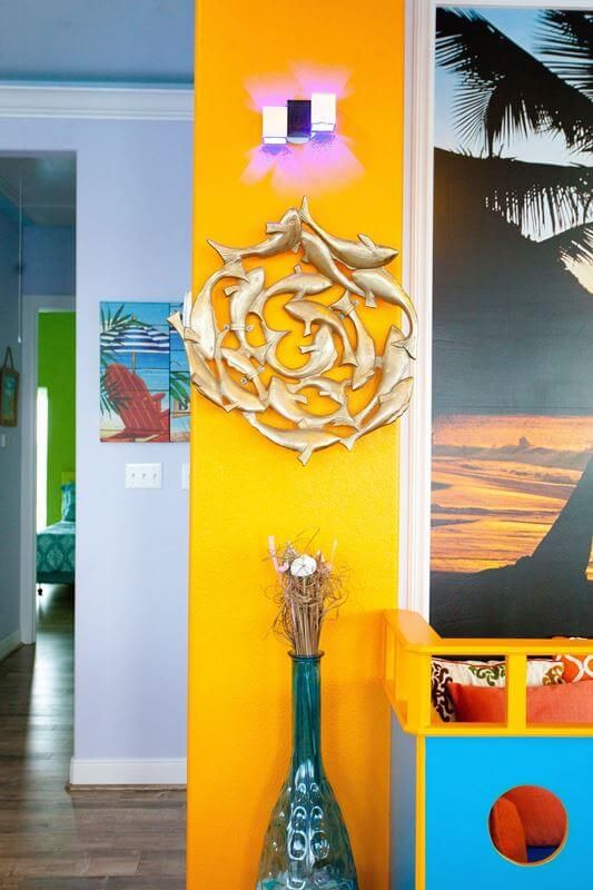 A yellow wall with a dolphin sculpture on it