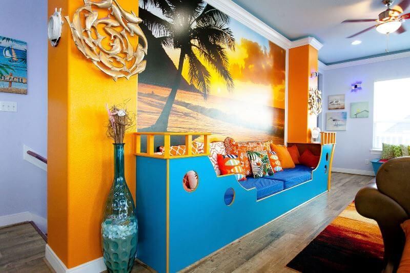 A living room with a couch in the shape of a pirate ship.