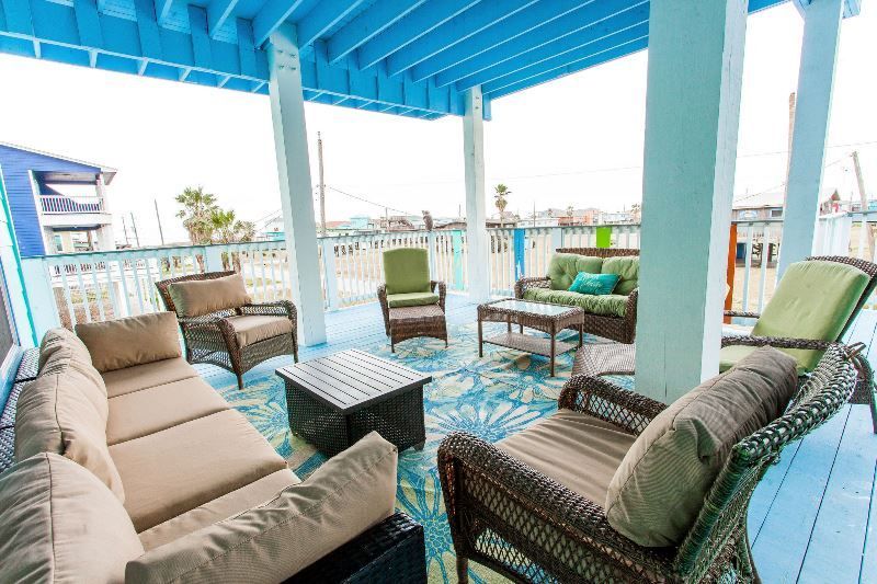 A patio with a lot of furniture and a blue roof.