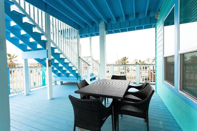 A blue deck with a table and chairs on it