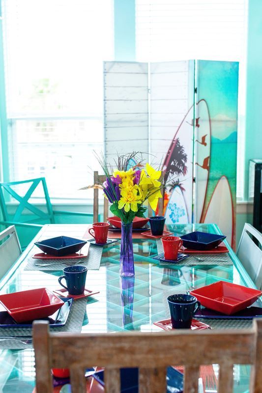 A dining room table with a vase of flowers on it