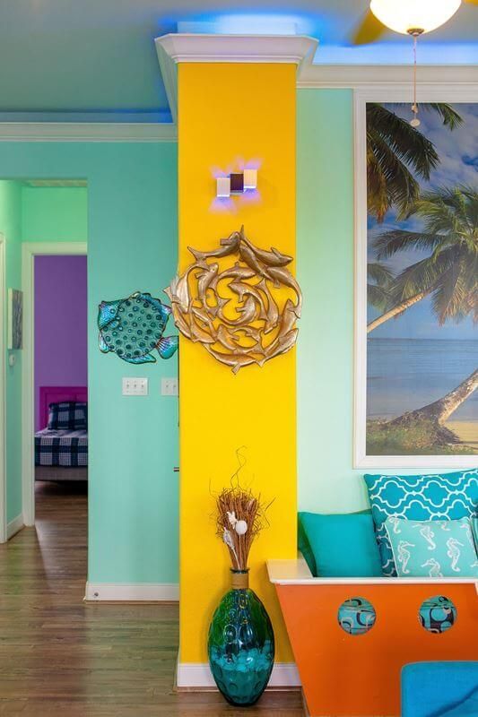 A living room with colorful walls and a painting on the wall