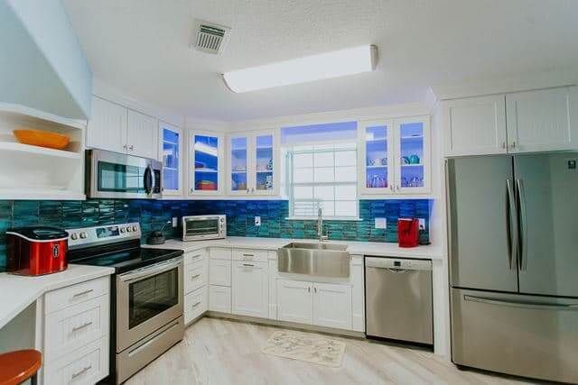 A kitchen with stainless steel appliances and white cabinets.