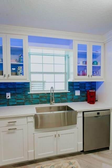 A kitchen with white cabinets and a stainless steel sink