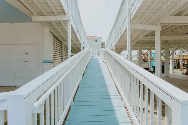 A ramp leading to a building with a white railing.