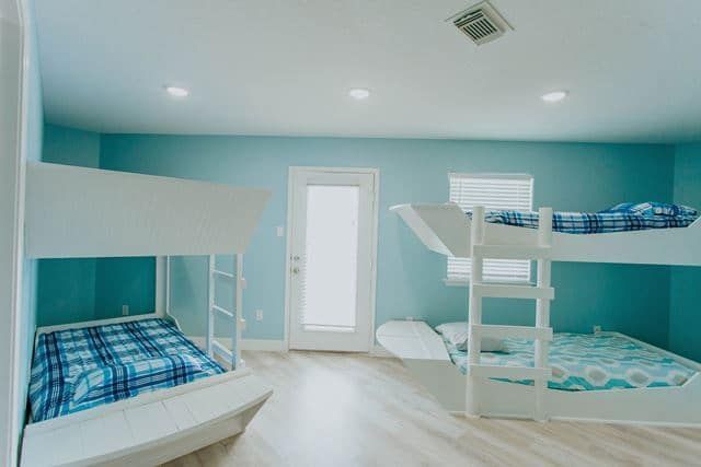 A bedroom with bunk beds and blue walls.