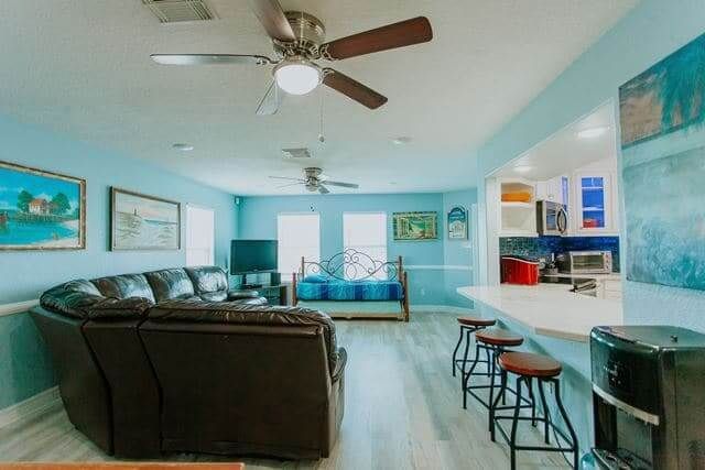 A living room with a couch and a ceiling fan.