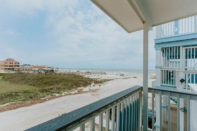 A balcony with a view of the ocean and a beach.