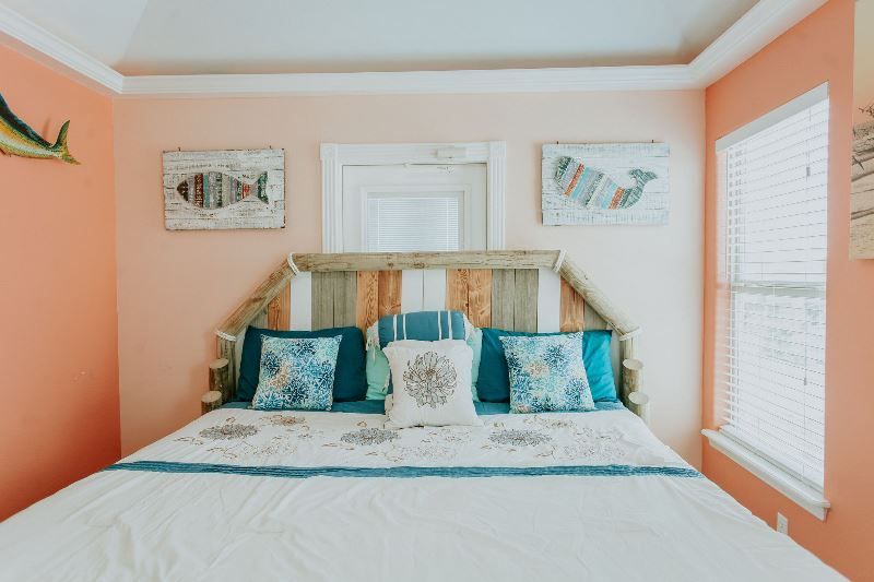 A bedroom with a king size bed and a fish on the wall.