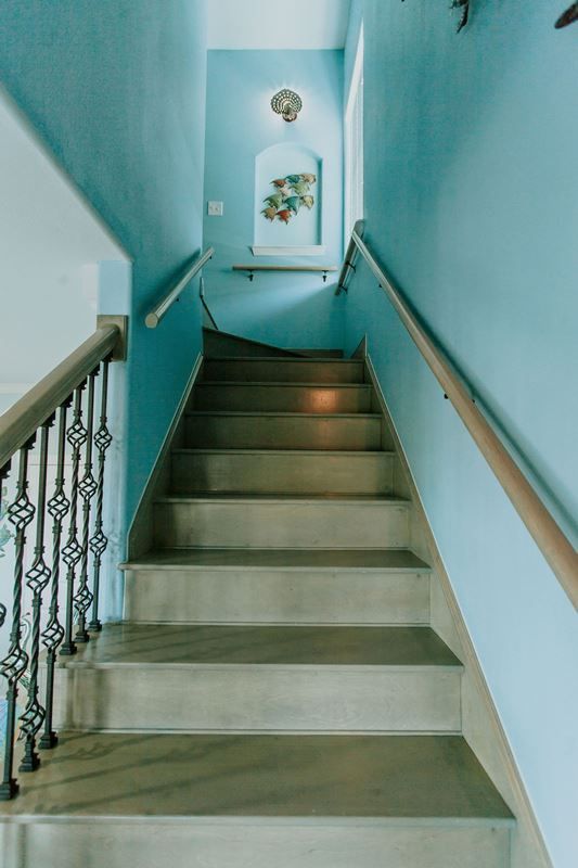 A set of stairs leading up to a second floor with blue walls.