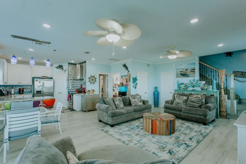 A living room filled with furniture and a ceiling fan.