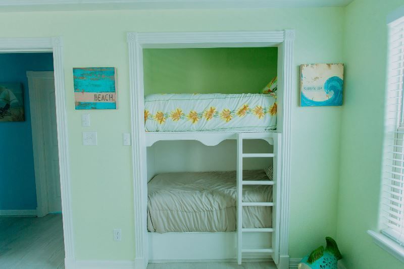 There is a bunk bed in the closet with a ladder.
