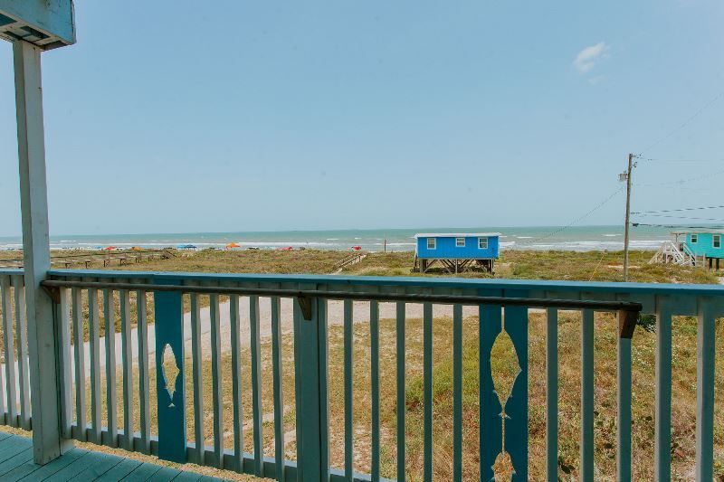 A view of the ocean from a deck with a blue railing.