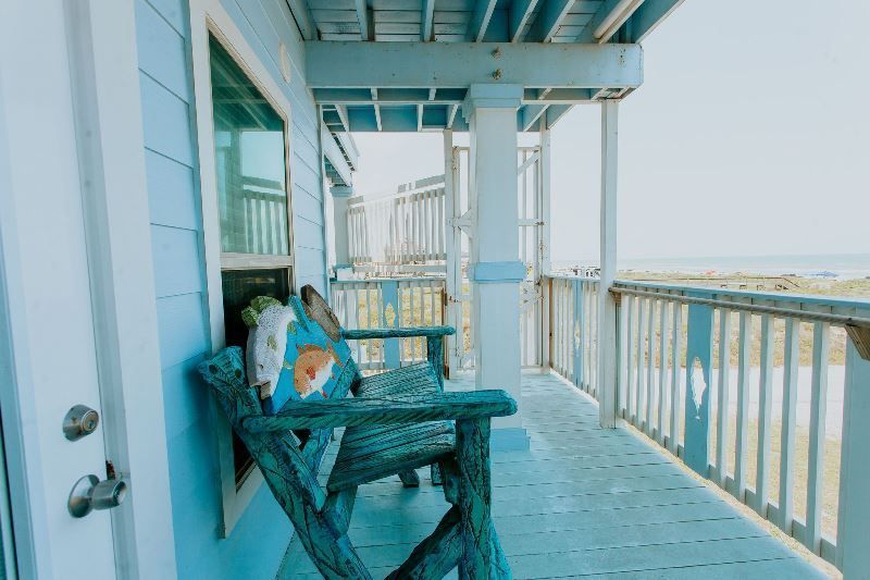 There is a chair on the porch of a house.