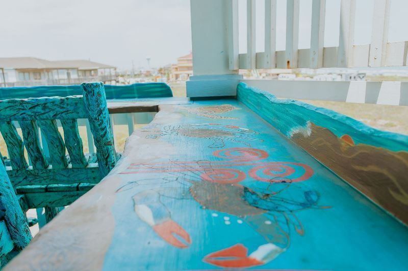 A blue table with crabs painted on it is on a balcony.