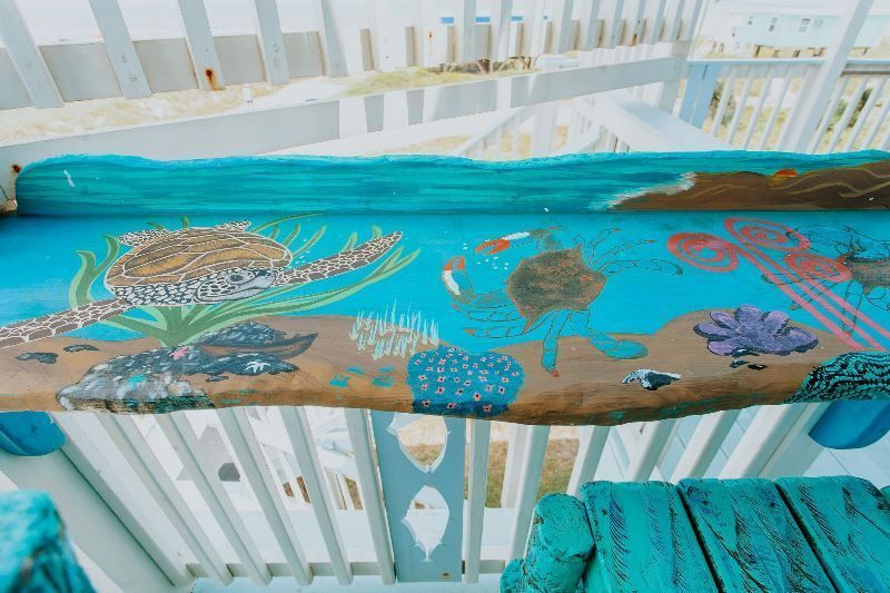 A wooden table with a painting of sea turtles and corals on it.