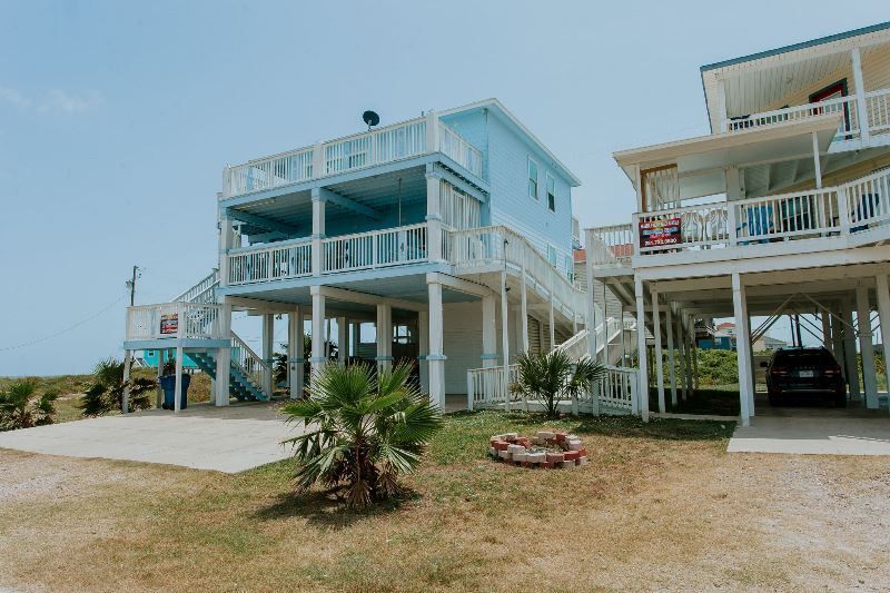 A couple of houses sitting next to each other on top of a hill.