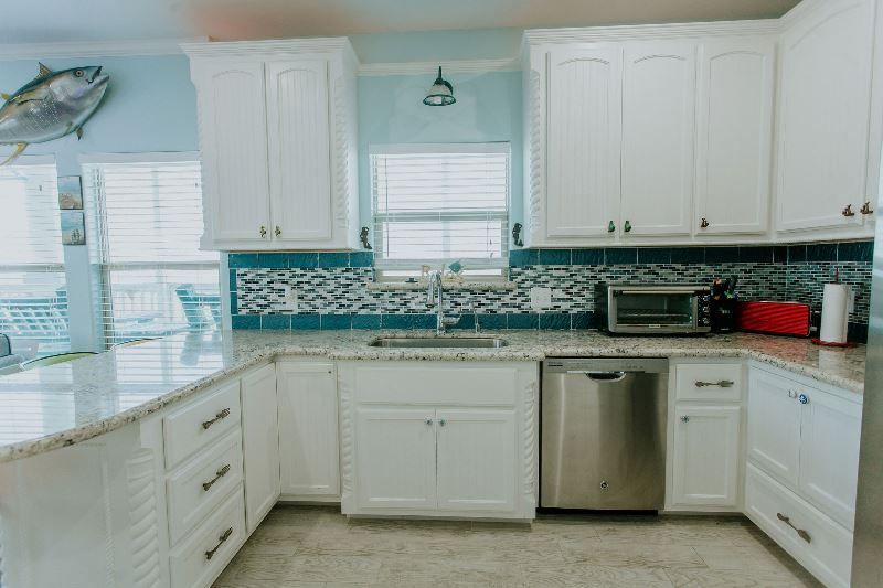A kitchen with white cabinets and stainless steel appliances.