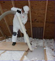 Technician removing insulation out of attic.