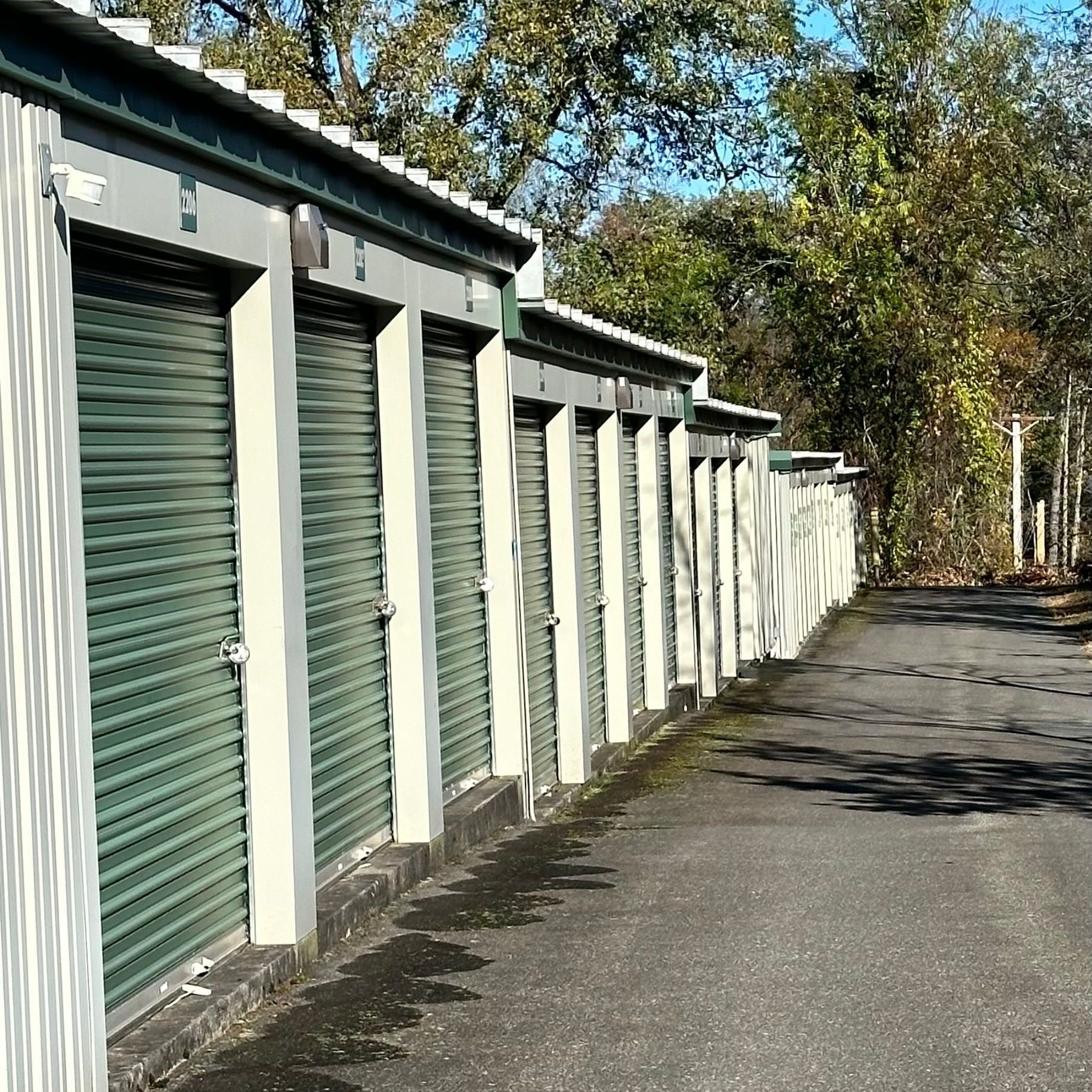 A man is locking a green locker with a key.