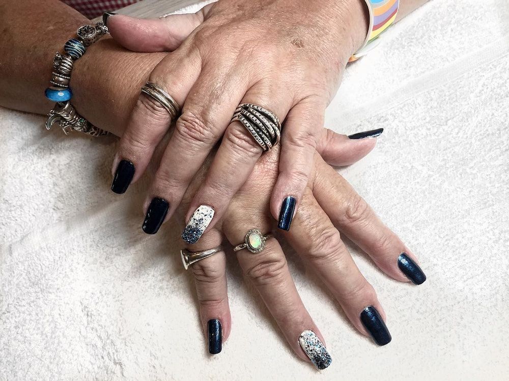 A Woman's Hands With Black Nails and Rings on Them — Erikka's All Occasion Beauty In Rockhampton City, QLD