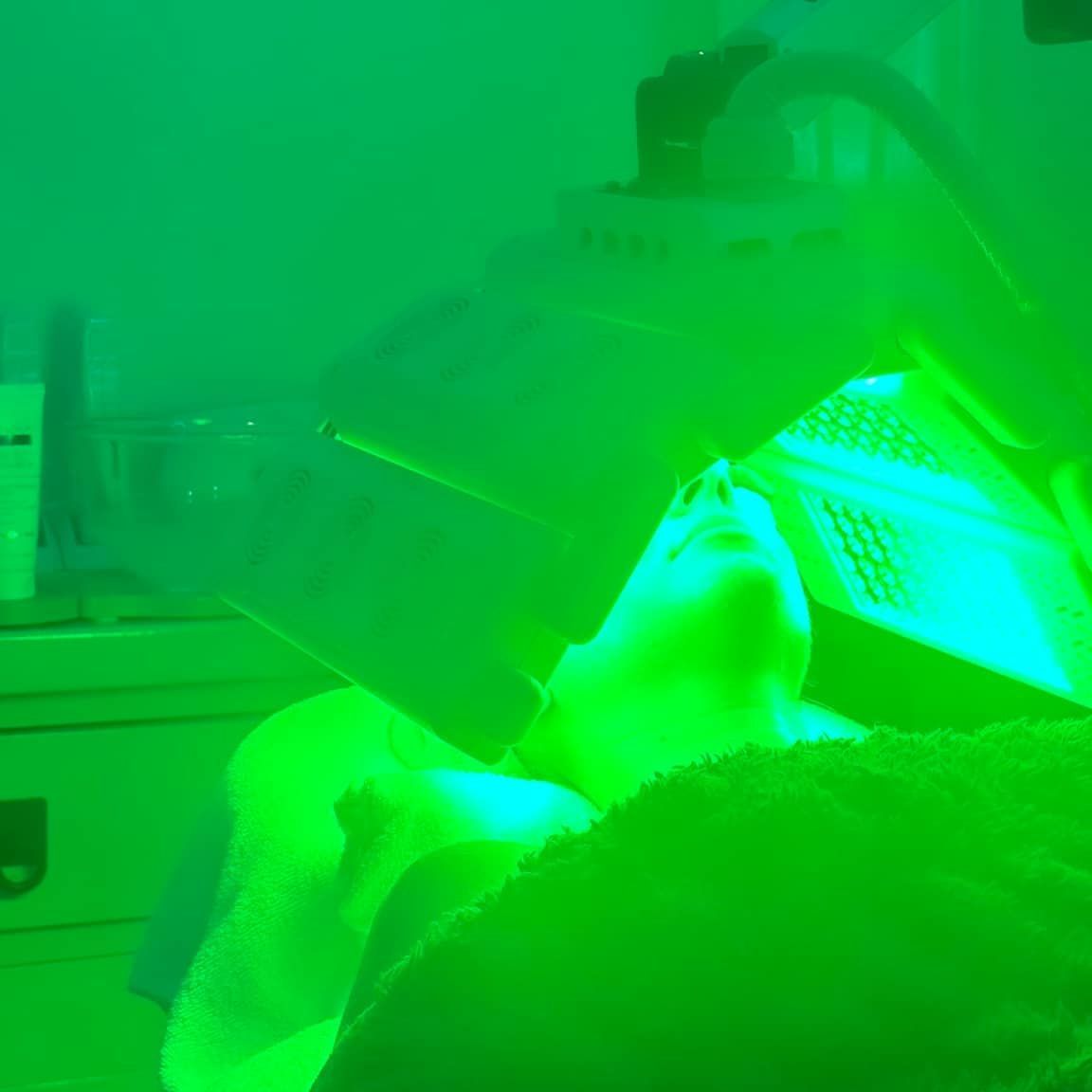 A Person is Getting a Green Light Treatment on Their Face — Erikka's All Occasion Beauty In Rockhampton City, QLD