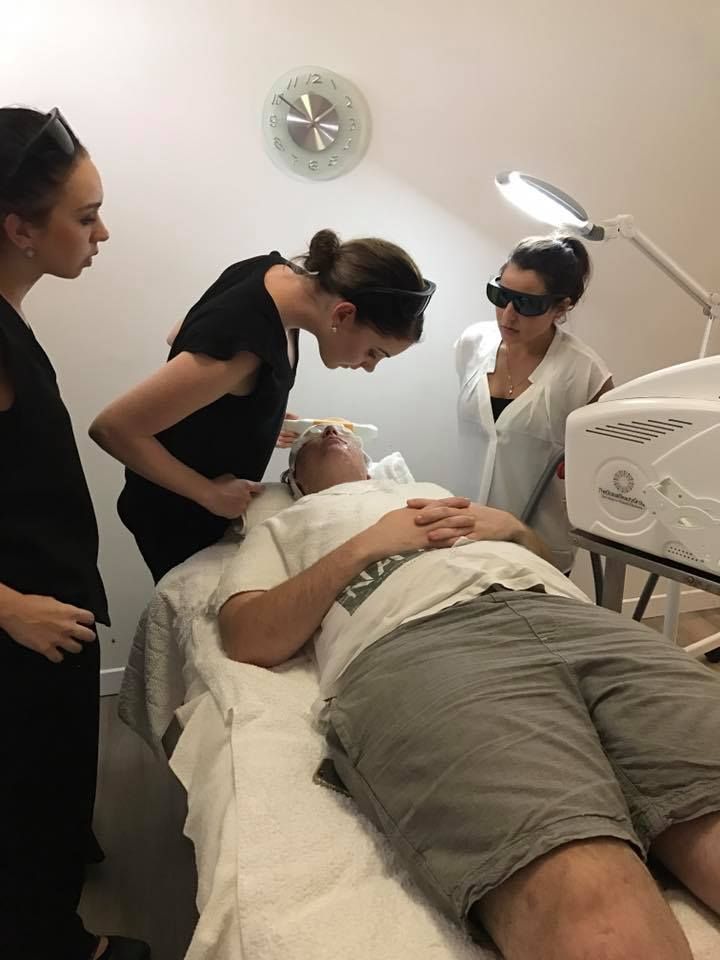 A Man is Laying on a Bed Getting a Laser Treatment — Erikka's All Occasion Beauty In Rockhampton City, QLD