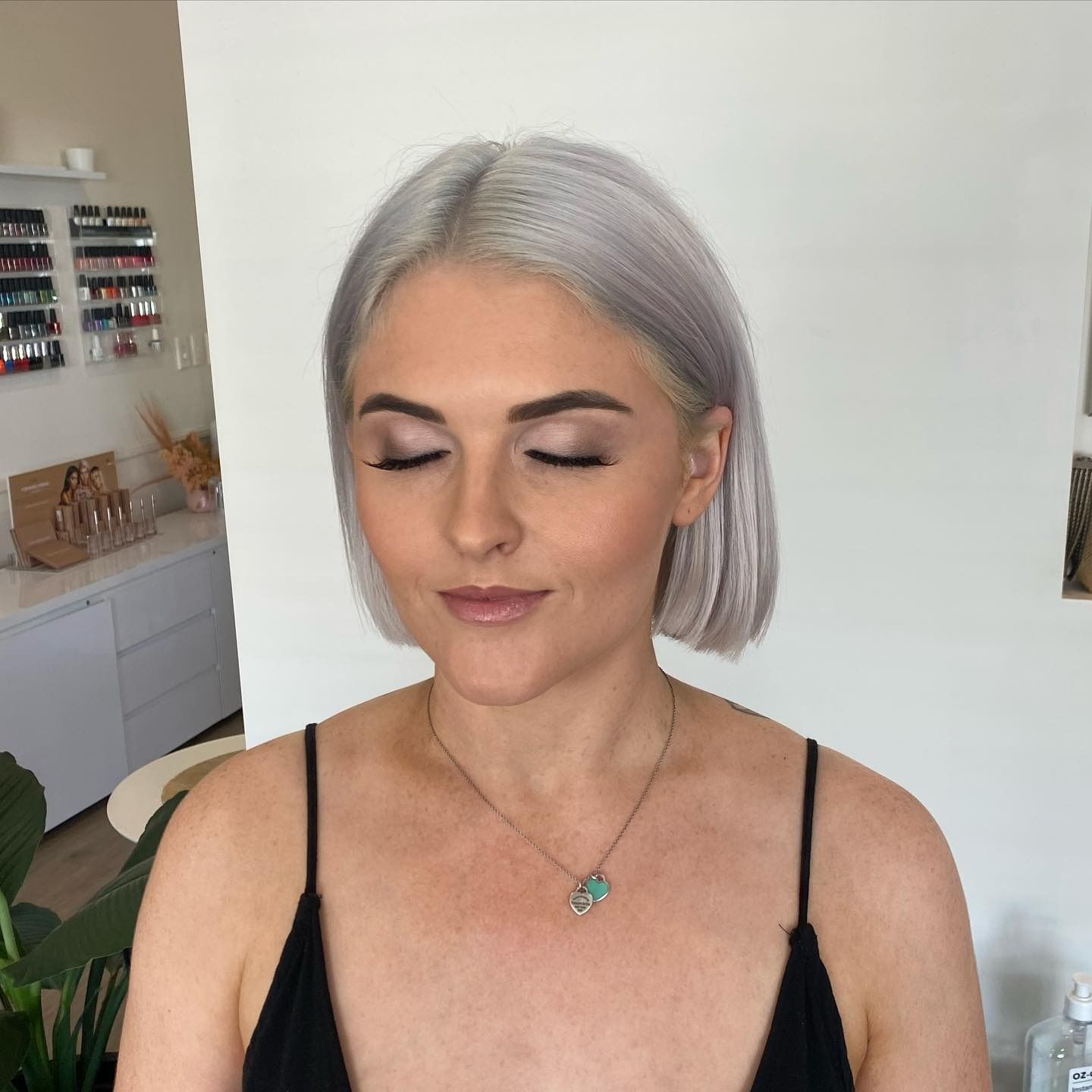 A Woman With Gray Hair is Wearing a Black Tank Top and a Necklace — Erikka's All Occasion Beauty In Rockhampton City, QLD