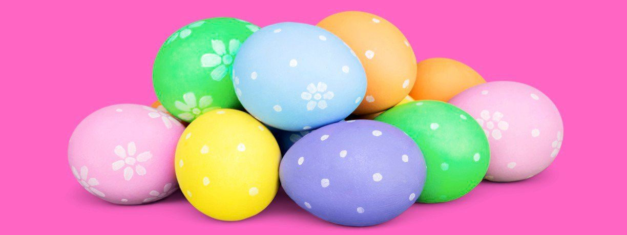 A pile of colorful easter eggs on a pink background