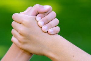 A close up of a person holding another person 's hand.